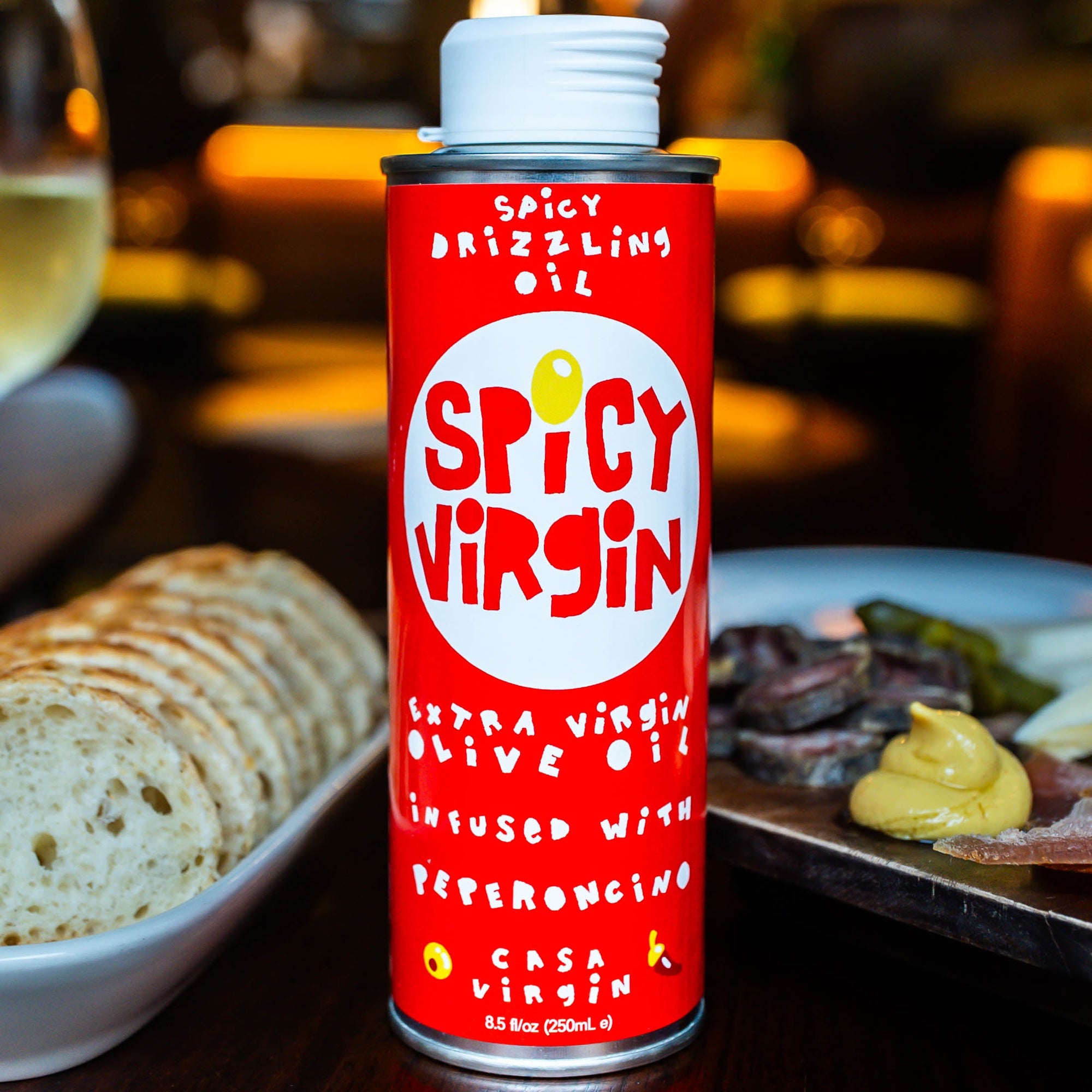 Casa Virgin Spicy Virgin Calabrian chili drizzling olive oil in 250ml tin on wooden table
